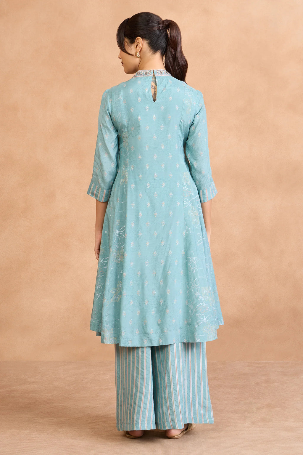 Back view of woman in mint green printed kurta with striped palazzo pants, elegant Indian ethnic wear