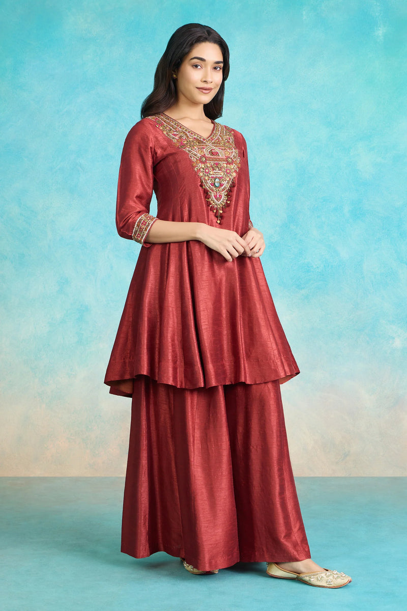Red embroidered Indian kurta set with flared skirt, perfect for festive occasions and special events.